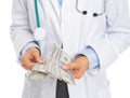 Closeup on doctor counting dollars