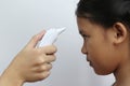 Closeup of Doctor examines or treatment child patient temperature on the forehead using electronic thermometer on white background Royalty Free Stock Photo