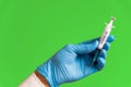 Closeup of doctor hand with gloves holding covid-19 vaccine syringe on green colorful background. concept of science and Royalty Free Stock Photo