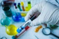 Closeup of a doctor with a latex glove holding a virus test tube in the laboratory Royalty Free Stock Photo