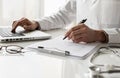 Closeup of doctor medical professional wearing uniform taking notes, physician, therapist or practitioner filling medical document Royalty Free Stock Photo