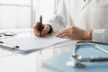 Closeup of doctor medical professional wearing uniform taking notes, physician, therapist or practitioner filling medical document Royalty Free Stock Photo