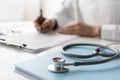 Closeup of doctor medical professional wearing uniform taking notes, physician, therapist or practitioner filling medical document Royalty Free Stock Photo