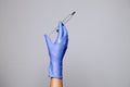 Closeup doctor or nurse hand in rubber latex medical purple glove holding a transparent syringe with sharp needle. ÃÂ¡oncept