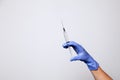 Closeup doctor or nurse hand in rubber latex medical purple glove holding a transparent syringe with sharp needle. ÃÂ¡oncept