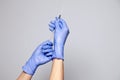 Closeup doctor or nurse hands in rubber latex medical purple gloves holding a transparent syringe with sharp needle. ÃÂ¡oncept