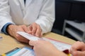 Closeup doctor and patient looking at booklet