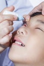 Closeup of doctor pouring eye drops in sick children