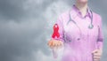 A doctor with red aid ribbon hanging above her hand