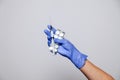 Closeup doctor's hand in rubber latex purple glove hold transparent syringe and pills in blister. Concept rejection of