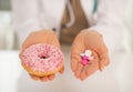 Closeup on doctor woman showing donut and pills Royalty Free Stock Photo
