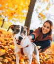 Closeup on dog on leash pulling woman outdoors in autumn Royalty Free Stock Photo