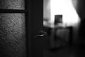 Closeup door with patterned glass and a chrome handle. Black and white photo