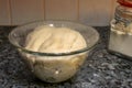 Closeup of dough in a bowl wrapped in a cling film on the table under the lights Royalty Free Stock Photo