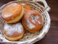 Closeup of doughnuts berliners on a bread basket on vintage wooden table