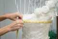 Dressmaker designer working with mannequin in wedding dress