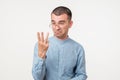 Closeup of drunk young man looking in his fingers trying to count them.