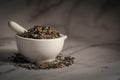 Closeup of Dry Bhringraj leaves, in white ceramic mortar and pestle.