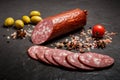 Closeup dry smoked salami sausage with green olives and tomato