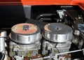 Closeup of dual carburetors on an automobile engine