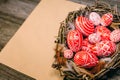 Closeup Easter eggs with pattern inside bird nest on right side of vintage sheet of paper on wood board. Top view Royalty Free Stock Photo