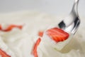 Closeup of eating fresh chopped strawberries with white yogurt