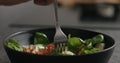 Closeup eating fresh salad with mozzarella and cherry tomatoes with fork