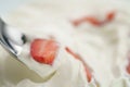 Closeup of eating with spoon organic sliced strawberries in whipped cream Royalty Free Stock Photo