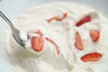 Closeup of eating with spoon organic sliced strawberries in whipped cream Royalty Free Stock Photo
