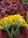 Edible pumpkin flowers and peaches sell in the market