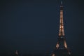 Closeup of the Eiffel Tower at night under the dark blue sky in France