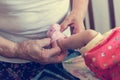 Closeup of elderly hands putting socks on newborn feet.