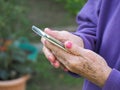 Closeup of elderly woman hands holding mobile phone