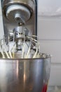 Closeup of electric mixer with whipped smooth dough for cake. Batter being whipped. Mixing white dough in bowl with motor mixer Royalty Free Stock Photo