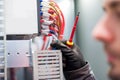 Closeup of electrician engineer works with electric cable wires Royalty Free Stock Photo