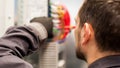 Closeup of electrician engineer works with electric cable wires Royalty Free Stock Photo