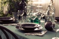 Closeup of elegant dining table with green tablecloth, black plates and wine glasses Royalty Free Stock Photo