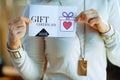 Closeup on elegant housewife holding gift certificate