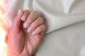 Closeup elegant pastel natural modern design manicure on fabric silk background. Female hands. Gel nails. Nude manicure Royalty Free Stock Photo