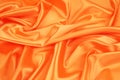 Closeup of elegant shiny orange silk background.