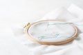 Closeup of an embroidery process, a green thread in a needle. Wooden embroidery frame for needlework. Workplace for Royalty Free Stock Photo