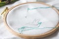 Closeup of an embroidery process, a green thread in a needle. Wooden embroidery frame for needlework. Workplace for Royalty Free Stock Photo