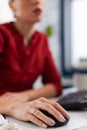 Closeup of employee hand in red shirt using wireless computer mouse. Royalty Free Stock Photo