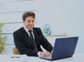 Closeup of employee in the office working on laptop computer.