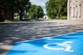Closeup of an empty handicapped reserved parking space painted blue with a white wheelchair symbol on black asphalt in the city Royalty Free Stock Photo