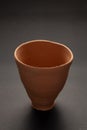 Closeup of Empty Indian Hand Made Clay Red Pot kulhad unglazed,  over black Background Royalty Free Stock Photo