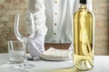Closeup of empty wine glass and bottle of white wine, waiter servig the table Royalty Free Stock Photo