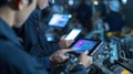 A closeup of engineers using handheld devices to interface with machinery focusing on screens that display diagnostics Royalty Free Stock Photo