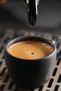 Closeup espresso last drop with single spout portafilter in black cup