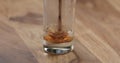 Closeup espresso pour into glass with cold water on wood table Royalty Free Stock Photo